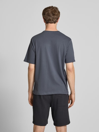 Männermodel trägt Regular Fit T-Shirt mit Logo-Print Modell 'Soho' van Jack & Jones, katoen, grijs, ruglengte maat M 61 cm, Ganzkörperansicht Rückansicht.