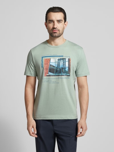 Männermodel trägt Regular Fit T-Shirt aus reiner Baumwolle von Tom Tailor, unifarben, Foto-Print, kurzer Ärmel, Rundhals, Jersey, Ganzkörperansicht von vorne