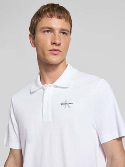 Männermodel trägt Easy Fit Poloshirt mit Polokragen von Calvin Klein Jeans, Reine Baumwolle, Label-Stitching, Nahaufnahme Oberkörper.