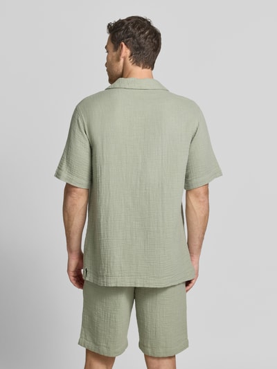 Männermodel trägt Relaxed Fit Freizeithemd mit Strukturmuster von Lindbergh aus Reiner Baumwolle in hellem Grün, Kurzärmelig, Reverskragen, Ganzkörperansicht Rückansicht.