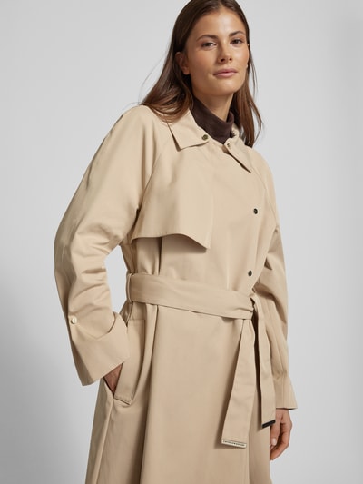 Frauenmodel trägt Mantel mit Logo-Detail von Emporio Armani aus Material-Mix mit Baumwoll-Anteil in Beige, detailverliebt, Nahaufnahme Oberkörper.