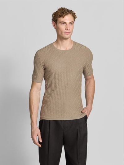 Männermodel trägt T-Shirt aus Viskose-Mix in Strick-Optik von Emporio Armani, feines Strickmuster, Beige, schmale Passform, Ganzkörperansicht von vorne.