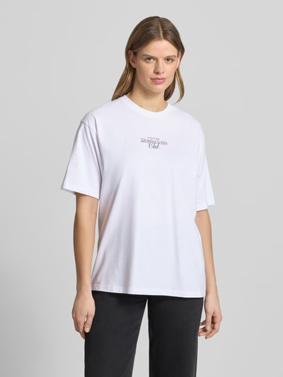 Kobiece modelka nosi damski t-shirt z bawełny model 'LATTE' od JJXX, biały kolor, krój loose fit, okrągły dekolt, długość tyłu w rozmiarze S: 65 cm, widok całej sylwetki z przodu.
