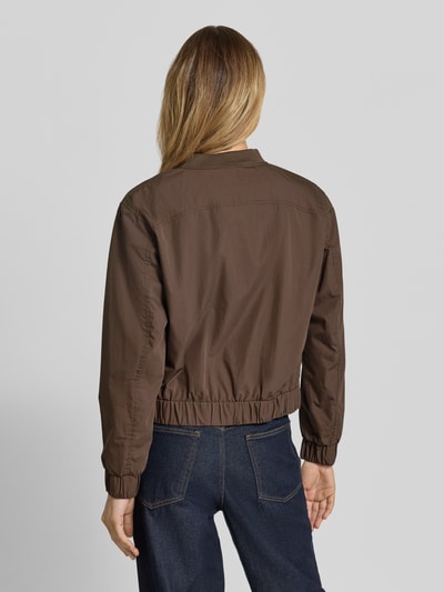 Frauenmodel trägt Jacke mit Pattentaschen von camel active aus mieszanka bawełny, krój regular fit, stójka, listwa guzikowa, kieszenie z patką, długość tyłu w rozmiarze 36: 54 cm, szerokość ramion w rozmiarze 36: 43 cm, szerokość klatki piersiowej w rozmiarze 36: 55 cm, długość rękawów w rozmiarze 36: 58 cm, brązowy kolor, gładka struktura, Ganzkörperansicht Rückansicht.