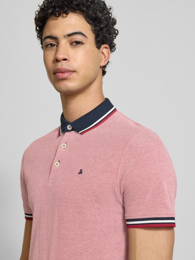Męski model trägt Slim Fit Koszulka polo z dodatkiem wiskozy Model 'Paulos' od JACK & JONES, mieszanka bawełny i wiskozy, kołnierzyk polo, krótki rękaw, wyhaftowane logo, długość tyłu w rozmiarze M: 72 cm, zbliżenie na górną część ciała z przodu.