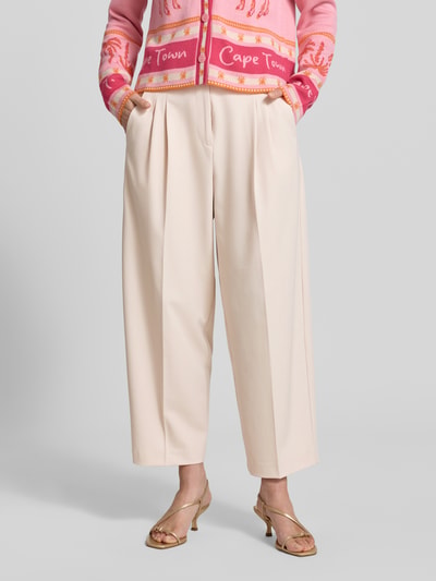 Frauenmodel trägt Straight Fit Cropped Hose mit Bügelfalten von Smith and Soul, Material-Mix mit Viskose-Anteil in Beige, Nahaufnahme Unterkörper.