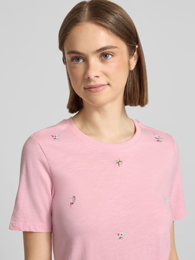 Frauenmodel trägt Regular Fit T-Shirt aus reiner Bio-Baumwolle Modell 'KETTY' von Only in Rosa mit Motiv-Stitching, Nahaufnahme Oberkörper.