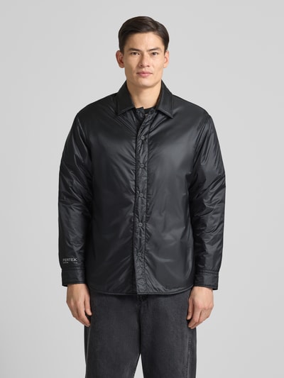 Męski model nosi Oversized Kurtka z wykładanym kołnierzem Model 'EVINUZ' od HUGO, jednokolorowa, wyhaftowane logo, długi rękaw, wpuszczane kieszenie, listwa guzikowa, materiał o gładkiej teksturze, widok całej sylwetki z przodu.
