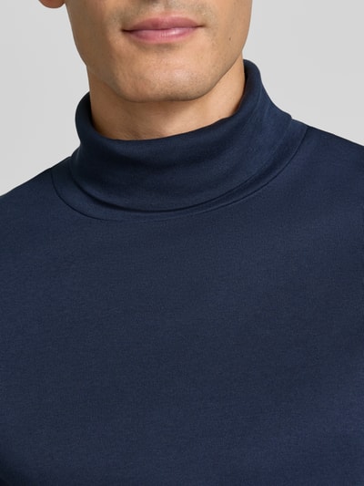 Männermodel trägt Regular Fit Longsleeve aus reiner Baumwolle mit Rollkragen von Christian Berg Men, dunkelblau, Nahaufnahme Oberkörper.