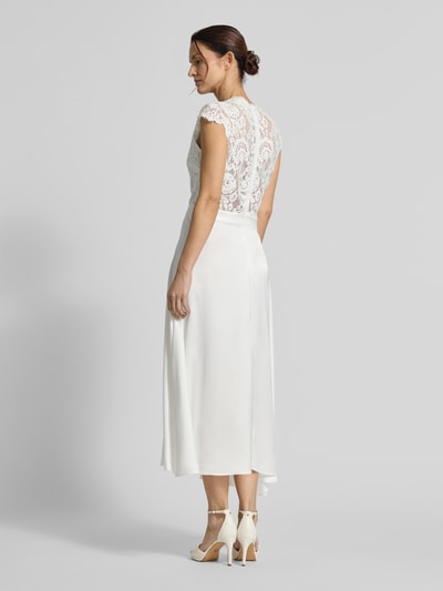 Frauenmodel trägt Brautkleid in Midilänge Modell 'Lilia' von GUIDO MARIA KRETSCHMER WOMAN, weiß, Spitze und Satin, tailliert, Ganzkörperansicht Rückansicht