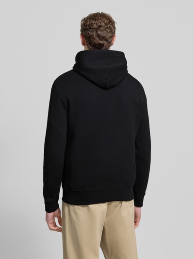 Männermodel draagt Hoodie met labelprint van Polo Ralph Lauren in zwart, katoenmix, los model, capuchon, ribboorden, ruglengte maat M 67 cm, mouwlengte maat M 65 cm. Ganzkörperansicht Rückansicht.
