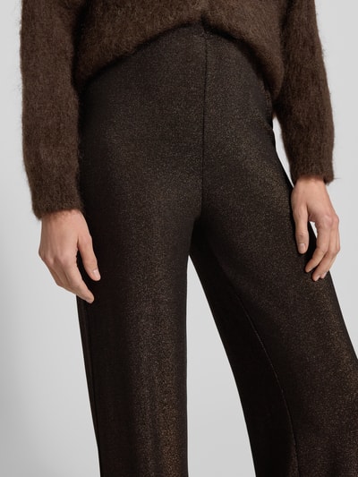Frauenmodel trägt schimmernde Hose mit elastischem Bund Modell 'KYRA' von VILLA SOPHIE, Material-Mix mit Stretch-Anteil, Nahaufnahme Oberkörper.