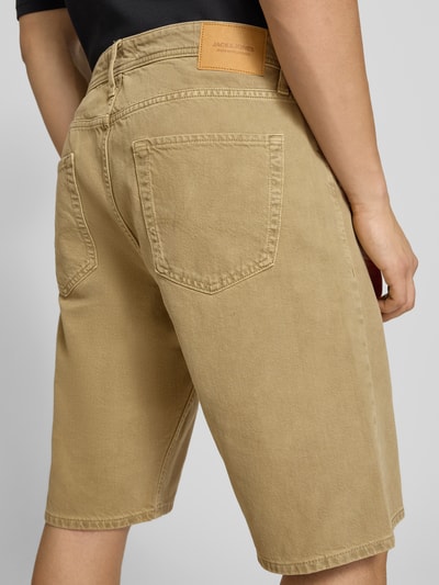 Männermodel trägt Baggy Fit Jeansshorts Modell 'ALEX' von Jack & Jones in Beige, reine Baumwolle, Eingrifftaschen, Ganzkörperansicht Rückansicht.