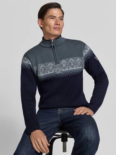 Männermodel trägt Wollpullover mit Troyer-Kragen Modell 'Moritz' von Dale of Norway, grau-blau gemustert, reine Wolle, Ganzkörperansicht von vorne.