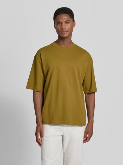 Męski model trägt Relaxed Fit T-Shirt mit Rundhalsausschnitt von JAKE*S STUDIO MEN z bawełny, kolor oliwkowy, krótki rękaw, długość tyłu w rozmiarze M 67 cm, Ganzkörperansicht von vorne.
