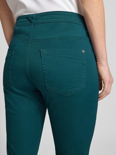 Frauenmodel trägt Tapered Chino aus Baumwoll-Mix von Tom Tailor in Uni-Optik, Relaxed Fit, 5-Pocket, Nahaufnahme Rückansicht.