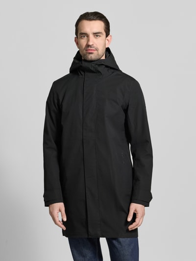 Męski model nosi Parka z patkami przy mankietach Model 'GEORGE' od Didriksons, czarna, krój regular fit, kaptur, całkowity widok z przodu, długość tyłu w rozmiarze M: 94 cm, szerokość ramion w rozmiarze M: 45 cm, szerokość klatki piersiowej w rozmiarze M: 55 cm, długość rękawów w rozmiarze M: 67 cm