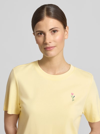 Frauenmodel trägt Regular Fit T-Shirt aus reiner Baumwolle von s.Oliver RED LABEL in Gelb mit Motiv-Print, Nahaufnahme Oberkörper.