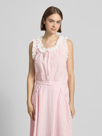 Frauenmodel trägt Cropped Blusentop mit Rüschen Modell 'Sona' von OH APRIL aus Reine Baumwolle, Schnürung, rosa-weiß kariert, Nahaufnahme Oberkörper.