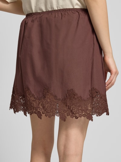 Frauenmodel trägt Minirock mit Spitze Modell 'LANI' von Topshop in Braun, A-Linie aus Reine Baumwolle, Gesamtlänge 43 cm, Nahaufnahme Rückansicht.