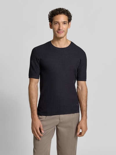 Männermodel trägt T-Shirt aus Viskose-Mix in Strick-Optik von Emporio Armani, schmale Passform, schwarze Farbe, Nahaufnahme Oberkörper.