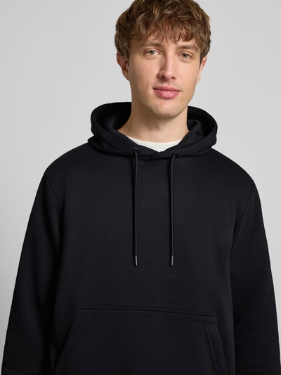 Männermodel trägt Hoodie mit Kapuze Modell 'BRADLEY' von Jack & Jones, Schwarz, Kängurutasche, Baumwoll-Mix, Nahaufnahme Oberkörper.