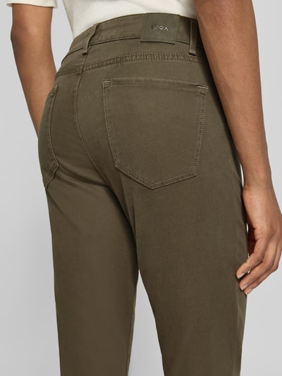 Frauenmodel trägt Slim Fit Schmale Hose aus Lyocell-Mix mit Modal-Baumwoll-Anteil Modell 'SHAKIRA' von Brax in Oliv, Damen Schmale Hose, Nahaufnahme Rückansicht.