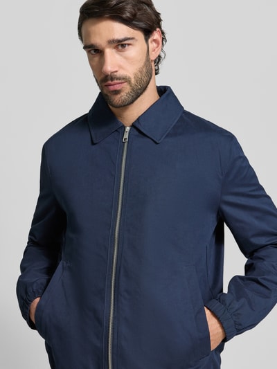 Männermodel trägt Regular Fit Jacke mit Umlegekragen von MCNEAL in Dunkelblau, Reißverschluss, elastische Abschlüsse, Nahaufnahme Oberkörper.