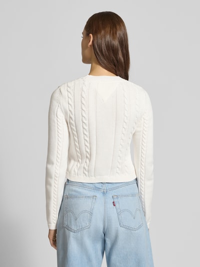 Frauenmodel trägt Slim Fit Strickpullover aus reiner Baumwolle von Tommy Jeans, Optik: Unifarben, Strickoptik, Ganzkörperansicht Rückansicht.