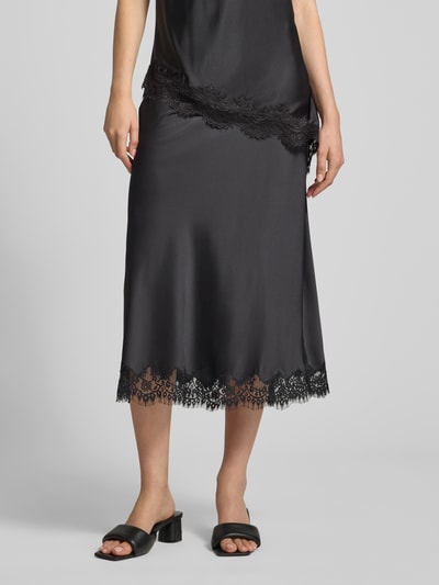 Frauenmodel trägt Ausgestellter Midi-Rock mit elastischem Bund Modell 'JESSA' von PIECES in Schwarz mit Spitzen-Details, Nahaufnahme Unterkörper. Damen Midi-Rock.