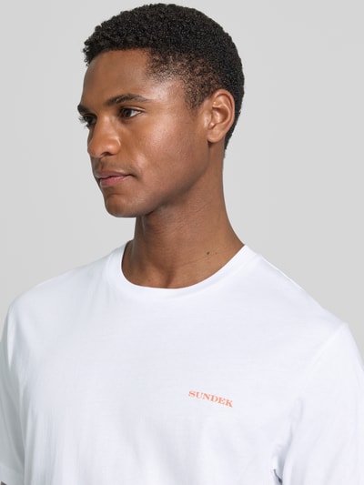Männermodel trägt T-Shirt mit rückseitigem Motiv-Print von Sundek in Weiß, Logo-Print vorn, reine Baumwolle, Regular Fit, Nahaufnahme Oberkörper.