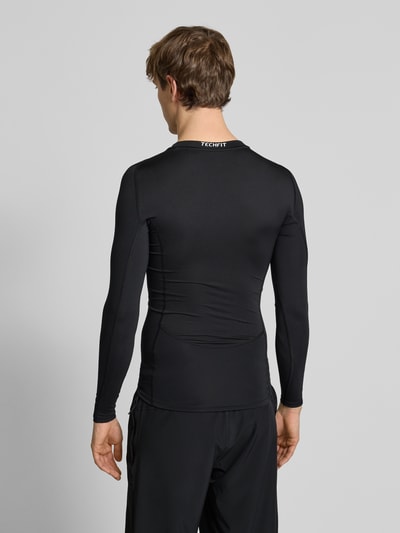 Mannenmodel draagt Shirt met lange mouwen met labelprint van adidas Training, materiaalmix met stretch, slim fit, ruglengte maat M 65 cm, geheel lichaamsaanzicht achteraan.