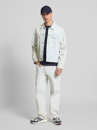 Männermodel trägt Straight Fit Jeans im Used-Look von Calvin Klein Jeans in hellem Denim, kombiniert mit Sneakers, Ganzkörperansicht von vorne. Reine Baumwolle, klassische Eingrifftaschen, Bundweite und Innenbeinlänge passend zu Größe 32/32, strukturierte Oberfläche.