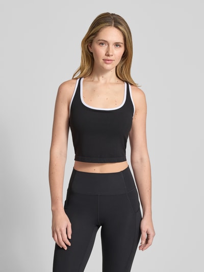 Frauenmodel trägt Cropped Top mit integriertem Bustier von Fabletics in Schwarz-Weiß, Elastischer-Material-Mix, Rückenausschnitt, Ganzkörperansicht von vorne. Rückenlänge bei Größe L: 13 cm.