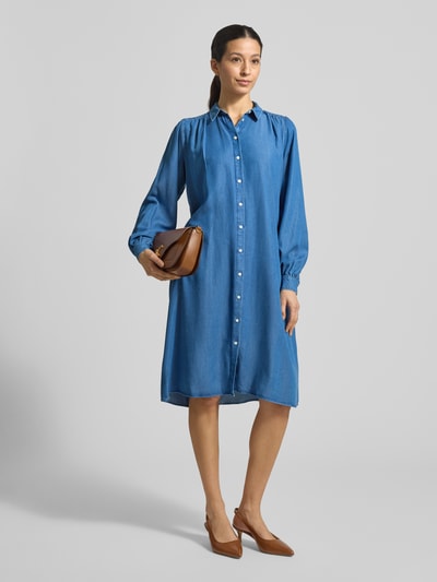Kobiece model nosi 'Knielanges Hemdblusenkleid in Denim-Optik' od Smith & Soul z Lyocellu, prosty krój, długość do kolan, imitacja denimu, kołnierzyk koszulowy, listwa guzikowa, długość tyłu w rozmiarze S: 104 cm, szerokość w rozmiarze S: 49 cm, długość rękawów w rozmiarze S: 65 cm; widok całej sylwetki od przodu.