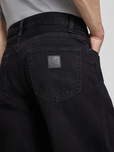 Männermodel trägt Wide Fit Jeans im 5-Pocket-Design Modell 'Aaron' von Carhartt Work In Progress, schwarze Baumwolle, Detailaufnahme Rückansicht