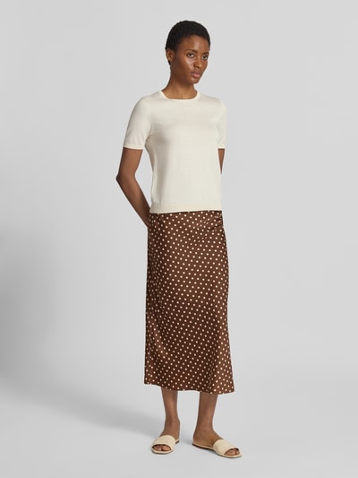 Kobiece model prezentuje spódnica midi w wzór na całej powierzchni Model 'PELLA' od YAS, Mieszanka materiałów z dodatkiem streczu, linia a, całkowita długość 84 cm, szerokość w rozmiarze S: 36 cm, widok całej sylwetki z przodu