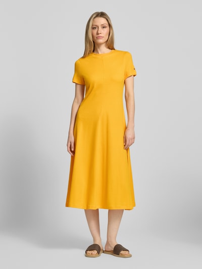 Frauenmodel trägt Midikleid aus reiner Baumwolle von Tommy Hilfiger in Optik: Unifarben, Regular-Fit, Midi-Länge, Rundhals, Kurzarm, Logo-Stitching, Materialverarbeitung: Interlock, Ganzkörperansicht von vorne.