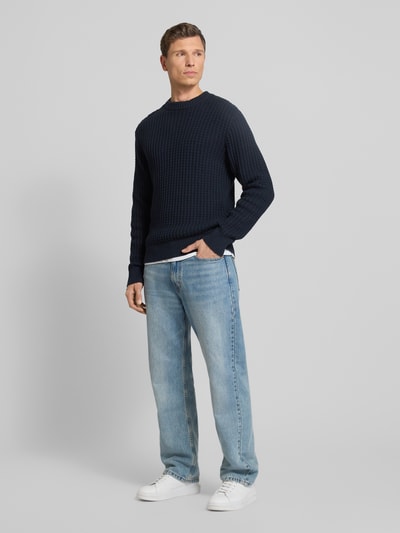 Männermodel trägt Regular Fit Strickpullover aus reiner Bio-Baumwolle Modell 'TOM' von SELECTED HOMME, marineblau, structuurpatroon, long sleeves, geribde boorden, unicolor, Ganzkörperansicht von vorne.