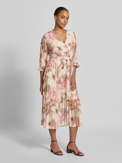 Vrouwenmodel draagt Midikleid met floralem allover-print Model 'Matilda' van ZABAIONE, getailleerde pasvorm, v-hals, 1/2-mouwen, zachtroze en beige tinten, plooien en lichte glans, Ganzkörperansicht von vorne.