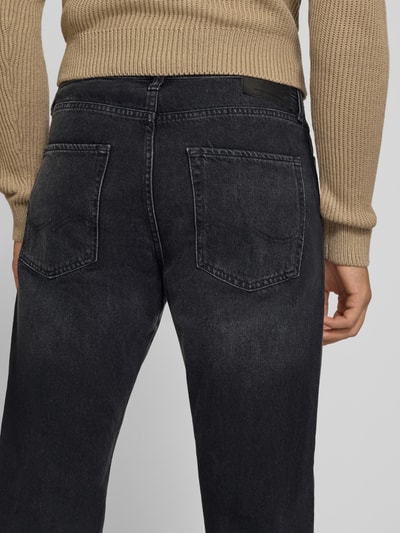 Frauenmodel trägt Straight Fit Jeans mit Escorial Woll-Anteil Modell 'Chris' von JACK & JONES, schwarzer Baumwoll-Mix, 5-Pocket-Design, Ganzkörperansicht Rückansicht.