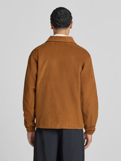 Männermodel trägt Loose Fit Bomberjacke aus reiner Baumwolle von Nike, kastanienbraun, strukturierte Oberfläche, Herren Bomberjacke, Ganzkörperansicht Rückansicht.