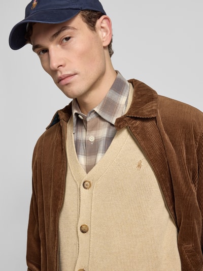 Męski model nosi Regular Fit Strickjacke aus reiner Baumwolle od Polo Ralph Lauren, beżowy sweter z logo, widok z przodu, zbliżenie na górną część ciała.