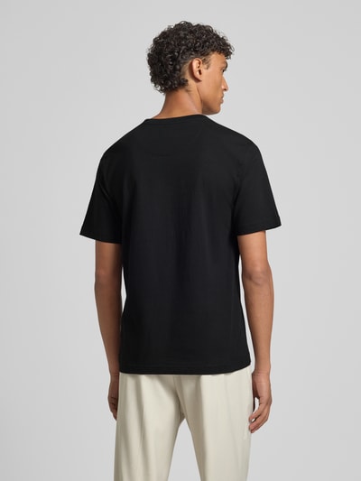 Männermodel trägt T-Shirt mit Motiv-Print Modell 'LUCAS' von Jack & Jones Premium in Schwarz, Slim Fit, Rückenansicht, Ganzkörperansicht.