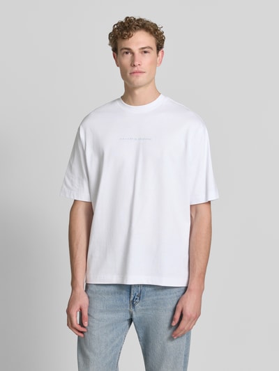 Männermodel trägt weißes Relaxed Fit T-Shirt aus reiner Baumwolle Modell 'NORMAN' von Selected Homme, dezente Struktur, Herren T-Shirt, Ganzkörperansicht von vorne.