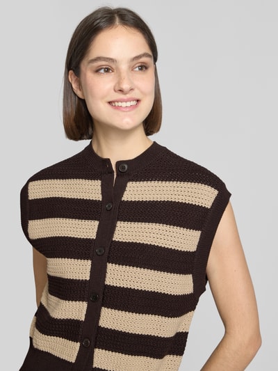Frauenmodel trägt Regular Fit Weste in Strick-Optik Modell 'Lydisy' von Drykorn aus Reine Baumwolle mit Knopfleiste, elastische Abschlüsse, beige-braun gestreift, Nahaufnahme Oberkörper.