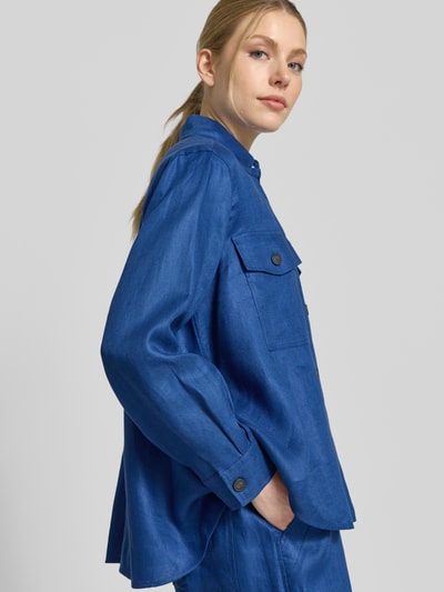Frauenmodel trägt Ausgestellte Hemdjacke aus reinem Leinen Modell 'POMPOSA' von Weekend Max Mara, einfarbig blau mit Brusttaschen, Nahaufnahme Oberkörper.