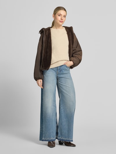 Frauenmodel trägt Relaxed Fit Blouson mit Wendefunktion von Marc O'Polo in Braun, kombiniert mit heller Jeans, Damen Bomberjacke, Ganzkörperansicht von vorne.
