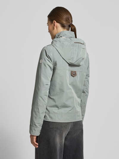 Vrouwenmodel draagt 'Jacke mit Kapuze und Reißverschlusstaschen' van Gil Bret in grijs met capuchon en ritszakken, regular fit, ruglengte 59 cm, schouderbreedte 40 cm, borstwijdte 51 cm, mouwlengte 63 cm, achterkant volledige lichaamsweergave.
