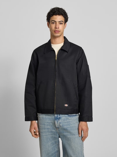 Männermodel trägt Jacke mit Reißverschluss Modell 'UNLINED EISENHOWER' von Dickies, Schwarz, Regular-Fit, Material-Mix, Eingrifftaschen, Label-Detail, Ganzkörperansicht von vorne.